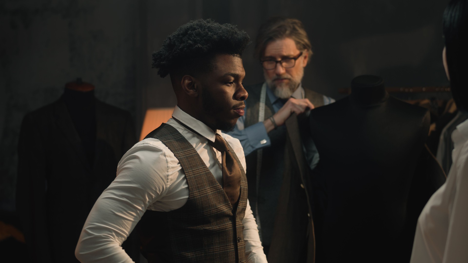 Jeune homme d’affaires en essayage de costumes dans un atelier