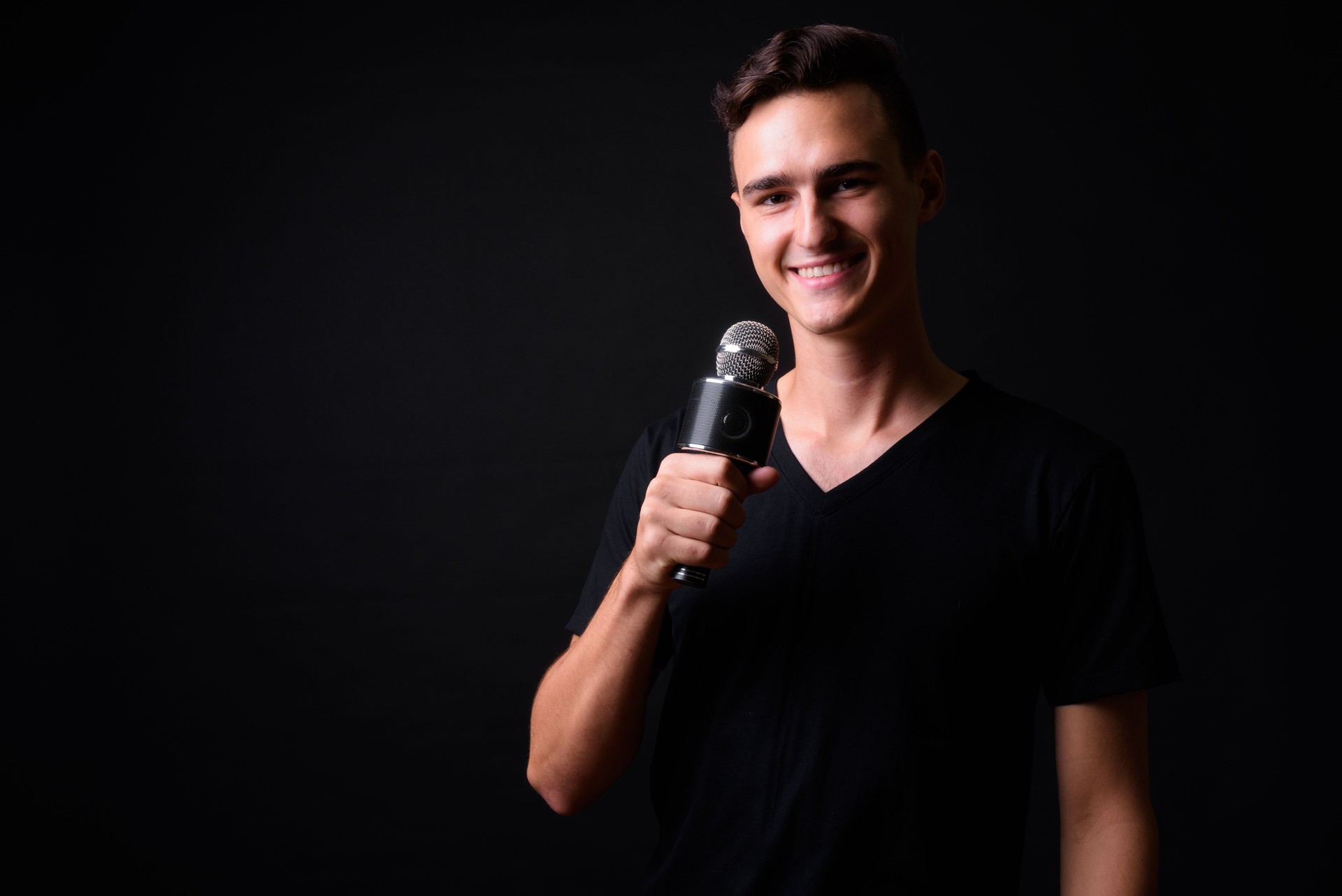 Bel homme chanteur avec Microphone sur fond noir